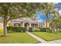 Beautiful two-story home with lush landscaping, a well-maintained lawn, and a covered front porch at 987 Alston Bay Blvd, Apopka, FL 32703