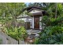 Inviting front entrance with a wood door, lush landscaping, and a picket fence, exuding warmth at 1000 E Anderson St, Orlando, FL 32801