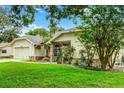 Side view of a single-story home with a well-manicured lawn and mature landscaping at 10119 Bayard Ct, Orlando, FL 32836