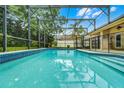 Screened in backyard pool with blue tiles and clear water reflecting the sky at 10119 Bayard Ct, Orlando, FL 32836