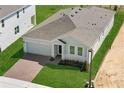 Aerial shot showcasing the home's roof, brick driveway, landscaping, and proximity to neighboring houses at 1026 Vineyard Ridge Rd, Minneola, FL 34715