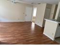 Living room featuring laminate flooring, a ceiling fan, and a breakfast bar between the kitchen and living area at 1089 S Hiawassee Rd # 314, Orlando, FL 32835