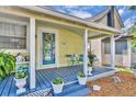 Inviting front porch with a blue deck, adorned with potted plants and comfortable seating, enhancing curb appeal at 1110 Virginia Ave, St Cloud, FL 34769