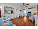 Bright living room with hardwood floors, white walls, a ceiling fan, and modern accents at 1110 Virginia Ave, St Cloud, FL 34769