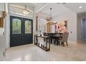 Elegant foyer with decorative glass double doors, travertine flooring, and views into the formal dining room at 11345 Preserve View Dr, Windermere, FL 34786
