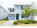 Two-story home with gray exterior, blue shutters, well-kept landscaping, and a one-car garage at 1577 Mulligan Blvd, Davenport, FL 33896