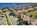 Stunning aerial view of a lakeside home showcasing the tile roof and lush landscaping near the water at 16675 Otterchase Ln, Winter Garden, FL 34787