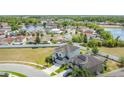 An aerial view captures the home's location near a tranquil lake and lush green spaces at 1671 Thetford Cir, Orlando, FL 32824