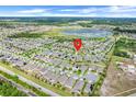 Expansive aerial view of a neighborhood featuring numerous homes, a scenic lake, and convenient road access at 1706 Lake Sims Pkwy, Ocoee, FL 34761