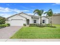 Charming home with a green lawn, complemented by tasteful landscaping and a brick driveway at 1706 Lake Sims Pkwy, Ocoee, FL 34761