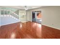 Bright living room with hardwood floors, sliding glass doors to the outside, and a view of the stairway at 1912 Cattleya Dr, Kissimmee, FL 34741