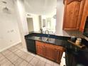 Cozy kitchen features black appliances, black countertops and tile flooring at 2528 Robert Trent Jones Dr # 1617, Orlando, FL 32835
