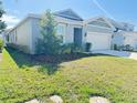 Well-maintained single-story home with a two-car garage, lush lawn, and landscaped garden at 2731 Forestdale St, St Cloud, FL 34771