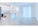 Open living space with tile floor and a view into the kitchen, flooded with natural light from a large window at 3239 Laurent Loop, Davenport, FL 33837