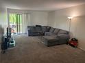 Spacious living room with plush carpeting, a comfortable sectional sofa, and sliding glass doors to the outside at 330 Scottsdale Sq # 330, Winter Park, FL 32792