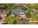 An aerial view of a beautiful home featuring a pond, manicured landscaping, and mature trees at 3418 Turningwind Ln, Winter Garden, FL 34787