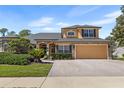 Beautiful two-story home with a manicured lawn, stone accents, and attached two-car garage at 3418 Turningwind Ln, Winter Garden, FL 34787