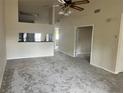 Open-concept living area featuring plush carpeting, a ceiling fan, and views into adjacent rooms at 3530 Forest Branch Dr # F, Port Orange, FL 32129