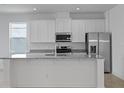 Bright kitchen featuring white cabinetry, stainless steel appliances, and granite island at 364 Lemongrass Rd, Minneola, FL 34715