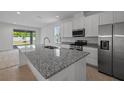 Modern kitchen featuring stainless steel appliances, granite countertops and island at 364 Lemongrass Rd, Minneola, FL 34715