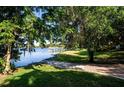 Scenic lake view framed by lush trees, showcasing a tranquil waterfront and a distant gazebo at 4 Island Dr, Lake Mary, FL 32746