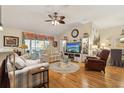Bright living room boasts hardwood floors, cozy seating, and a large window for natural light at 433 Arcadia Lakes Dr, The Villages, FL 32162