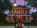 Elegant two-story home featuring a charming front porch and balcony with classic design elements at 4350 New Broad St, Orlando, FL 32814