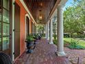 Inviting front porch featuring classic columns, a brick floor, and cozy seating to enjoy the outdoors at 4350 New Broad St, Orlando, FL 32814
