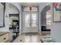 Elegant foyer with double doors, tiled flooring, arched doorways, and stylish decor at 440 Skyview Pl, Chuluota, FL 32766