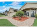 Beautiful home with a brick walkway, lush landscaping, and a well-maintained three-car garage at 440 Skyview Pl, Chuluota, FL 32766