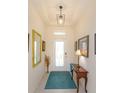 Inviting entryway features a decorative front door, tiled floors, and stylish lighting fixture at 6960 Audobon Osprey Cv, Harmony, FL 34773