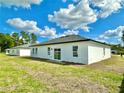 A spacious backyard view featuring a well-kept lawn and the rear exterior of a single-story home at 701 Marion Oaks Trl, Ocala, FL 34473