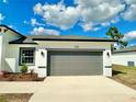 This exterior shot showcases a spacious two-car garage and well-maintained lawn of a single-story home at 701 Marion Oaks Trl, Ocala, FL 34473