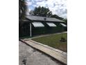 Charming home featuring a dark green exterior, metal roof, fenced yard and white window awnings at 710 W Swoope W Ave, Winter Park, FL 32789
