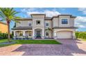 Stately two-story home with lush landscaping, a brick driveway, and a grand entrance at 711 Windlass Ct, Kissimmee, FL 34746