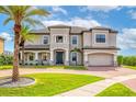 Stately two-story home with lush landscaping, a brick driveway, and a grand entrance at 711 Windlass Ct, Kissimmee, FL 34746