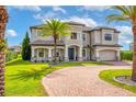 Stately two-story home with lush landscaping, a brick driveway, and a grand entrance at 711 Windlass Ct, Kissimmee, FL 34746