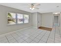 Bright, tiled living room featuring a ceiling fan, large window, and neutral paint at 7709 Pine Hollow Ct, Orlando, FL 32822