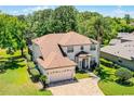 Aerial view of a two-story home with a brick driveway and lush landscaping in a wooded area at 772 Pickfair Ter, Lake Mary, FL 32746