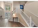 Bright foyer featuring a staircase with white railings, wood floors, and natural light from the front doors at 8208 Westminster Abbey Blvd, Orlando, FL 32835