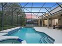 Inviting pool area surrounded by a screened enclosure with a jacuzzi for outdoor relaxation and entertainment at 8404 Secret Key Cv, Kissimmee, FL 34747