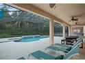 Relaxing pool area features covered patio with ceiling fans, lounge chairs and a dining area at 8404 Secret Key Cv, Kissimmee, FL 34747