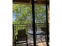 Cozy balcony with a round table, chairs, and a view of lush greenery at 12527 Floridays Resort Dr # 311E, Orlando, FL 32821
