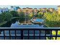 View of a relaxing pool area surrounded by lush landscaping and a tranquil lake at 12527 Floridays Resort Dr # 311E, Orlando, FL 32821