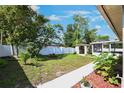 Spacious backyard featuring a shed, some plants, a white privacy fence and green grass at 1819 E Chapel Dr, Deltona, FL 32738