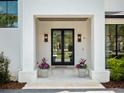 Charming home entrance with double doors, potted plants, and elegant exterior lighting at 9508 Sloane St, Orlando, FL 32827