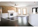 Open living room featuring a decorative wood accent wall, fireplace, and hardwood floors at 132 Alachua Dr, Winter Haven, FL 33884