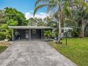 Charming single-story home with carport and lush landscaping, including palm trees and a well-manicured lawn at 3407 Silverwood Dr, Orlando, FL 32808