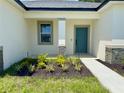 Close up of front door with small flower bed and manicured grass at 4295 Nw 1St Court Rd, Ocala, FL 34475
