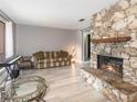Bright living room featuring a stone fireplace, light wood floors, and a comfortable seating area at 490 Burnt Tree Ln, Apopka, FL 32712